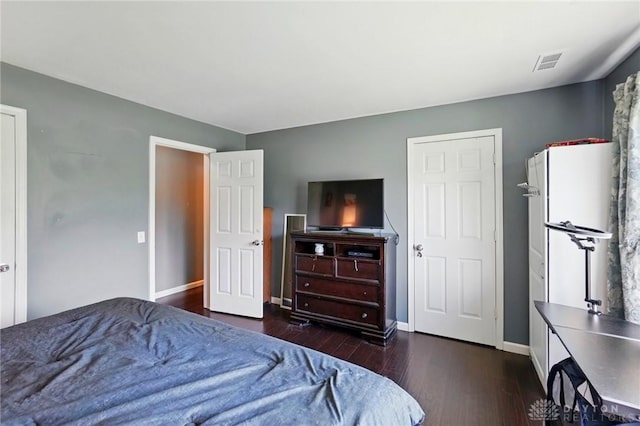 bedroom with dark wood-style floors, baseboards, and visible vents
