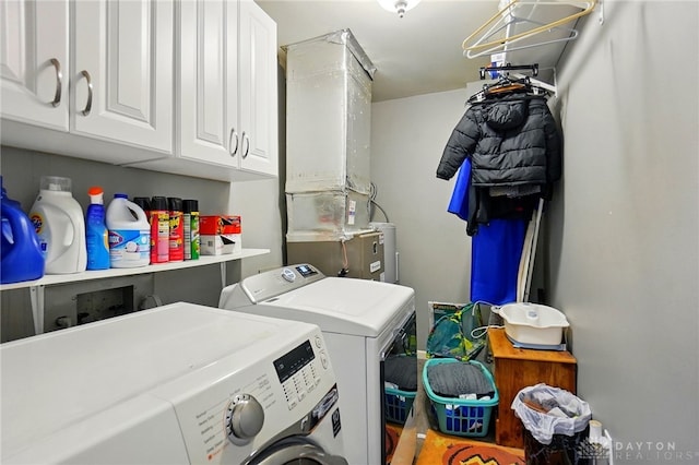 clothes washing area with washer and dryer, cabinet space, and heating unit