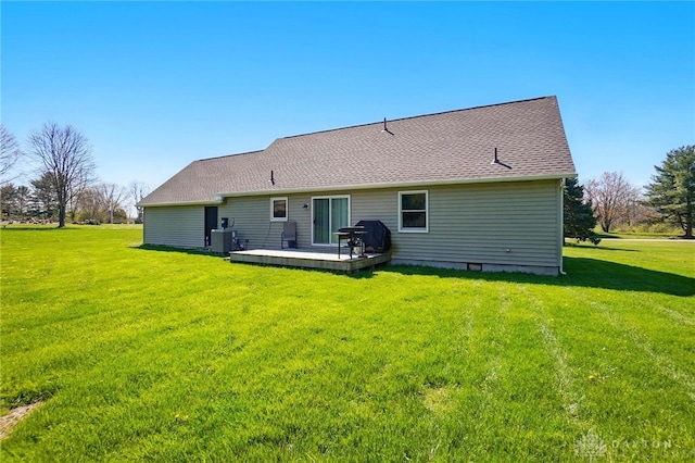 back of property with a wooden deck, roof with shingles, a yard, and cooling unit