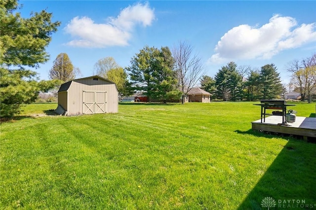 view of yard featuring an outdoor structure, a storage unit, and a wooden deck