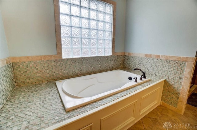 full bath with tile walls, a garden tub, tile patterned flooring, and a wainscoted wall