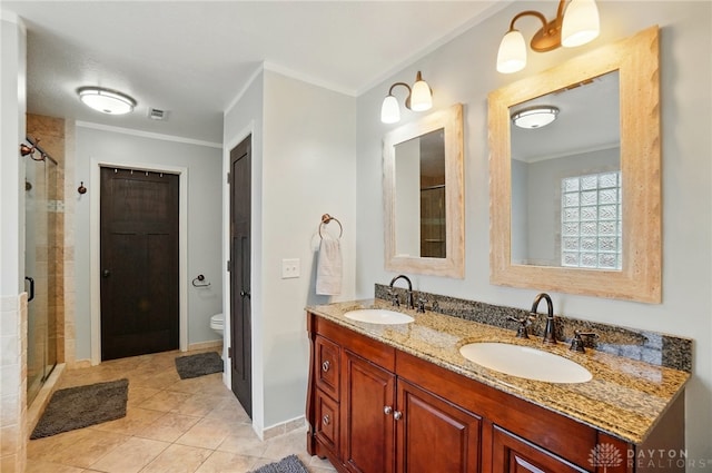 bathroom featuring double vanity, a shower stall, ornamental molding, and a sink