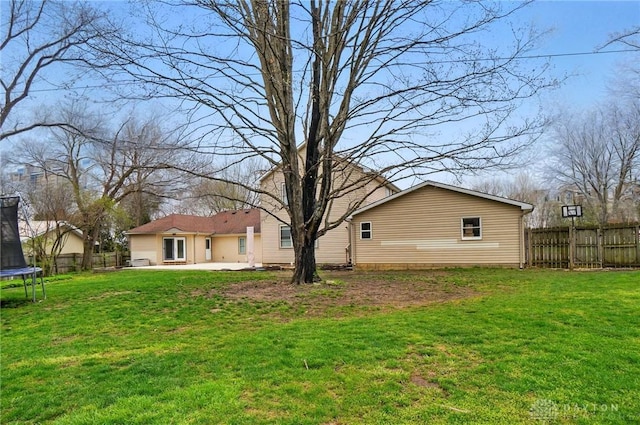 view of yard with fence, a patio area, and a trampoline