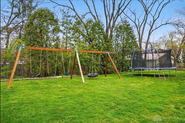 view of play area featuring a yard, a trampoline, an outdoor fire pit, and fence