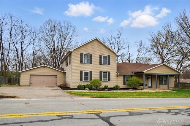 traditional-style house featuring fence, a detached garage, and covered porch