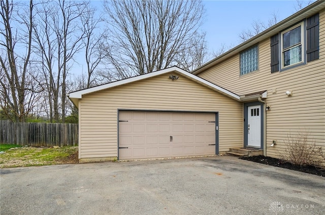 garage with fence and aphalt driveway