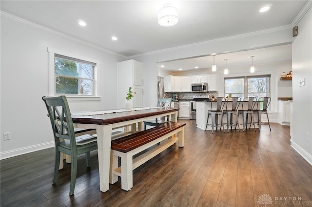 dining space with crown molding, dark wood-style floors, and plenty of natural light