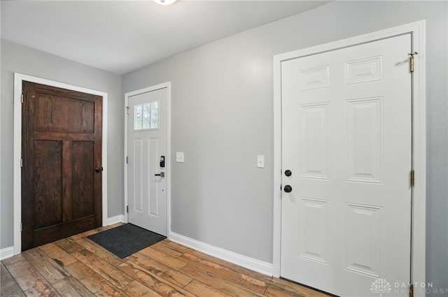 entryway with light wood-style flooring and baseboards