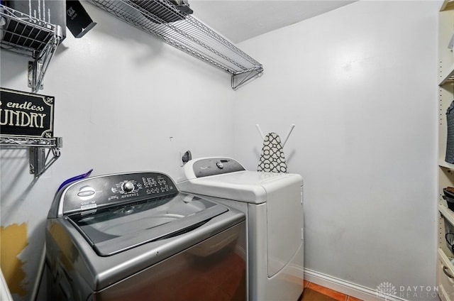 clothes washing area with baseboards, laundry area, and independent washer and dryer