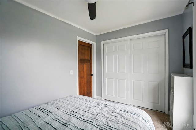 unfurnished bedroom with carpet floors, a closet, ornamental molding, and ceiling fan