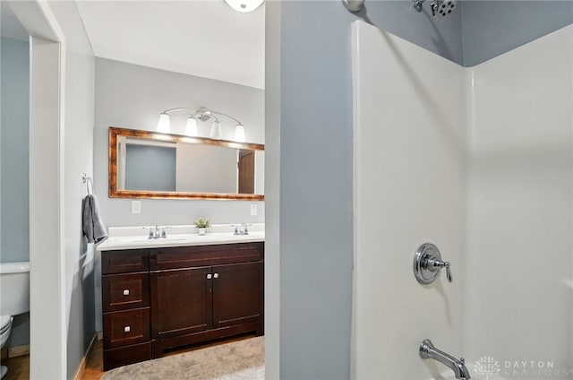 bathroom featuring toilet, a sink, and double vanity