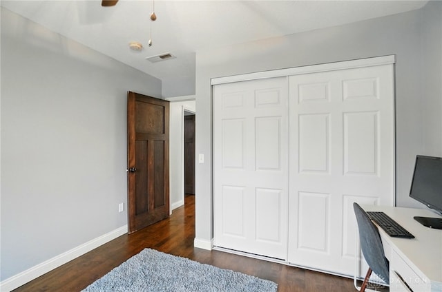 bedroom with dark wood finished floors, baseboards, visible vents, and a closet