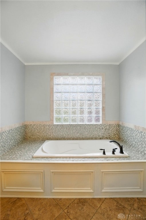 bathroom with a bath, plenty of natural light, tile patterned flooring, and ornamental molding