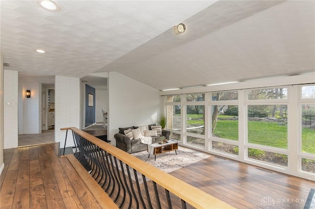 330 Rumson St, Englewood, OH 45322 - living area with wood-type flooring, vaulted ceiling, brick wall, and recessed lighting
