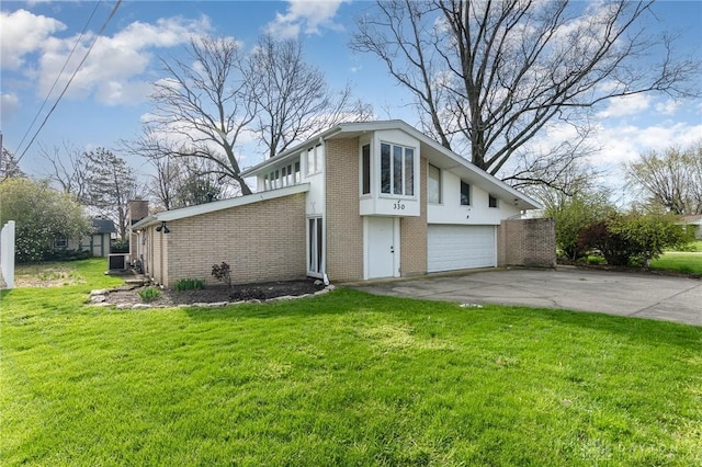 330 Rumson St, Englewood, OH 45322 - view of front facade with concrete driveway, a front lawn, an attached garage, cooling unit, and brick siding