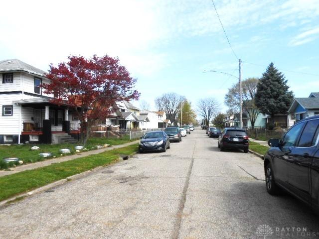 view of road featuring a residential view, sidewalks, curbs, and street lights