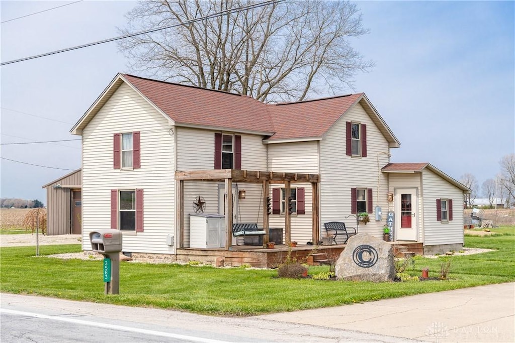 traditional-style home with a pergola, roof with shingles, a patio area, and a front yard