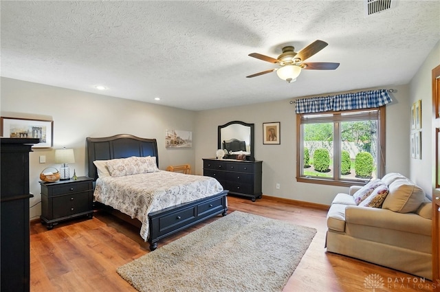 bedroom featuring recessed lighting, light wood-style floors, visible vents, and a textured ceiling