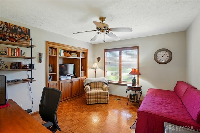 office with visible vents, a ceiling fan, baseboards, and a textured ceiling