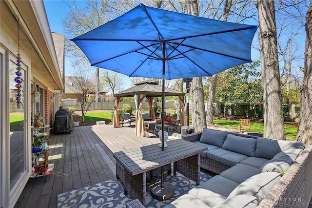 wooden terrace featuring a fenced backyard, outdoor lounge area, and a gazebo