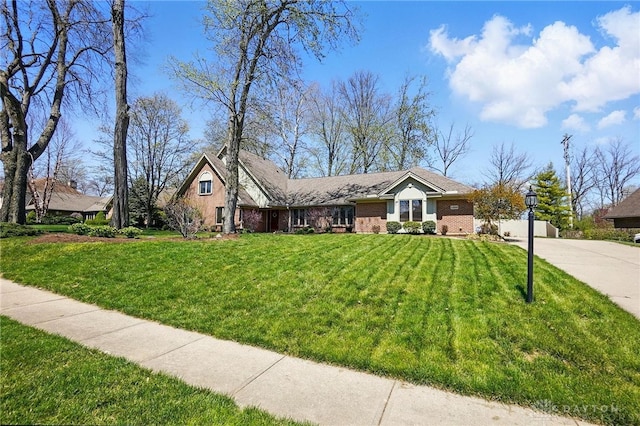 ranch-style home with driveway, brick siding, and a front yard