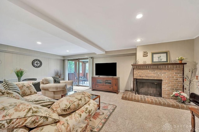 carpeted living area with a brick fireplace, recessed lighting, ornamental molding, and a decorative wall