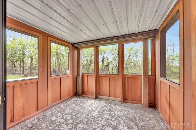 unfurnished sunroom featuring a wealth of natural light and wood walls
