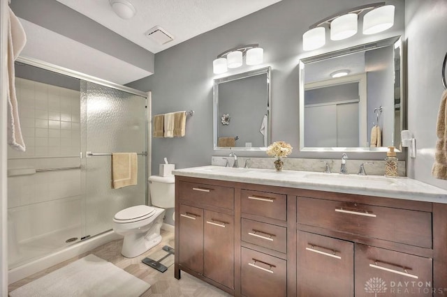 full bathroom featuring a shower stall, visible vents, toilet, and a sink