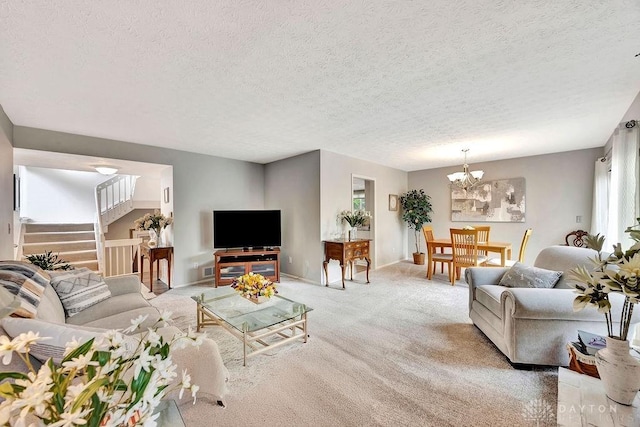 living room featuring an inviting chandelier, light colored carpet, baseboards, a textured ceiling, and stairs