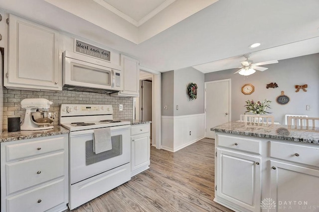 kitchen featuring white cabinets, a ceiling fan, white appliances, and tasteful backsplash