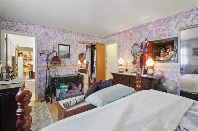 bedroom with wallpapered walls, a closet, and ensuite bathroom