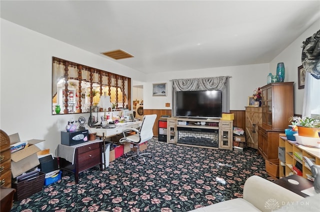 living room featuring wooden walls, a wainscoted wall, visible vents, and carpet