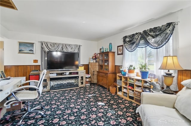 living area featuring wainscoting, wooden walls, visible vents, and carpet floors