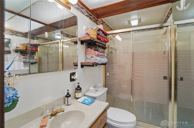 bathroom with vanity, a shower stall, and toilet