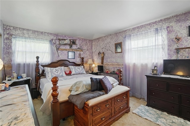 bedroom with light carpet, multiple windows, and wallpapered walls