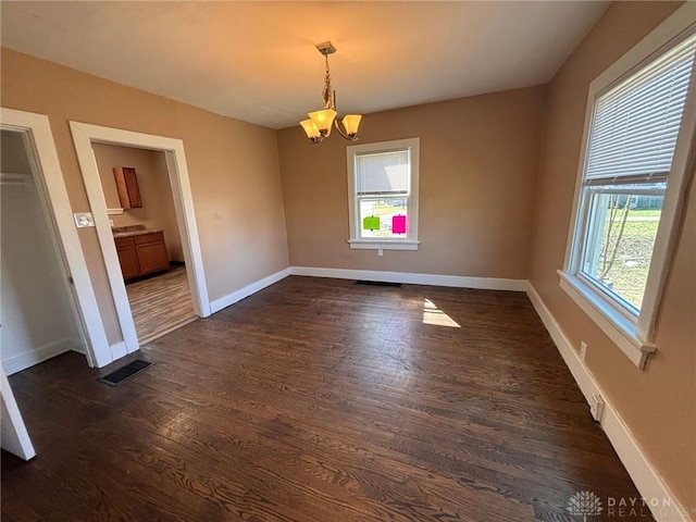 unfurnished dining area with baseboards, dark wood-style floors, and an inviting chandelier