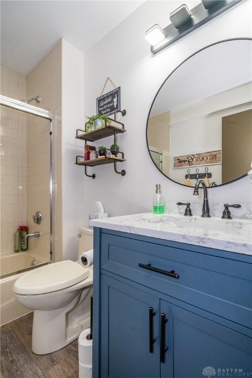 6475 Landsend Ct, Butler Township, OH 45414 - full bath with enclosed tub / shower combo, toilet, vanity, and wood finished floors