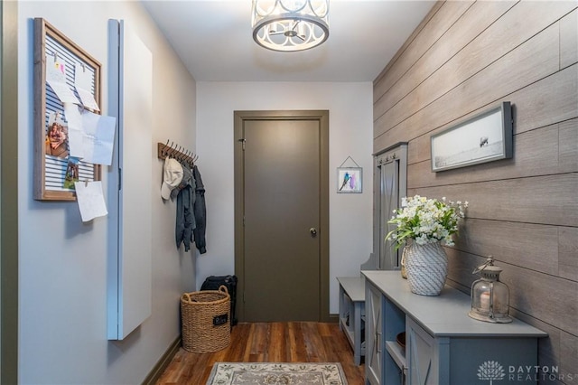 6475 Landsend Ct, Butler Township, OH 45414 - doorway with dark wood finished floors, wood walls, a notable chandelier, and baseboards