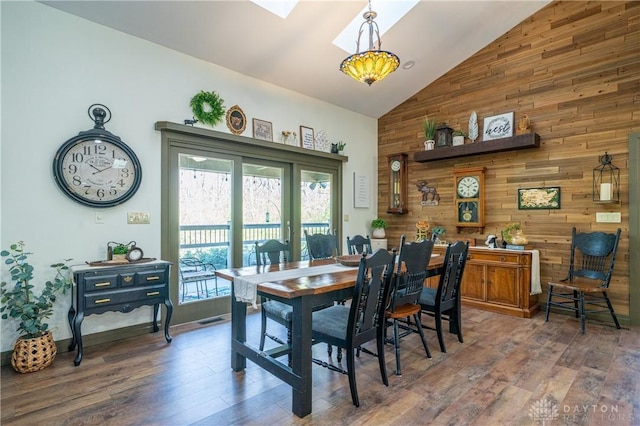 6475 Landsend Ct, Butler Township, OH 45414 - dining room featuring hardwood / wood-style floors, wooden walls, high vaulted ceiling, and a skylight