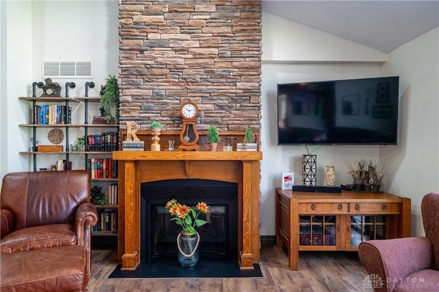 6475 Landsend Ct, Butler Township, OH 45414 - living area featuring vaulted ceiling, a large fireplace, wood finished floors, and visible vents