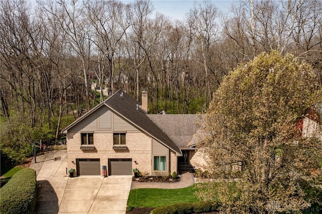 6475 Landsend Ct, Butler Township, OH 45414 - view of front of property featuring an attached garage, driveway, brick siding, and a chimney