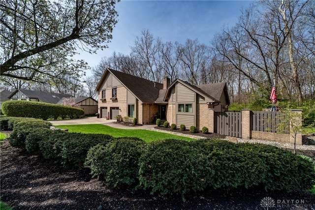 6475 Landsend Ct, Butler Township, OH 45414 - view of front of home featuring a chimney, driveway, fence, a garage, and brick siding