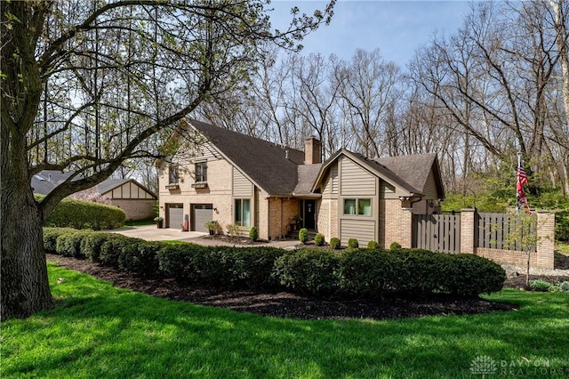 6475 Landsend Ct, Butler Township, OH 45414 - view of front of house featuring a chimney, concrete driveway, a garage, brick siding, and a front yard