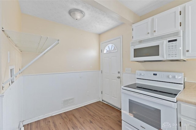 40 E Pease Ave, Dayton, OH 45449 - kitchen with light wood finished floors, white cabinets, visible vents, white appliances, and light countertops