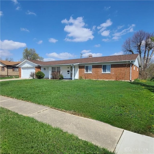 ranch-style home featuring brick siding, a front yard, and a garage