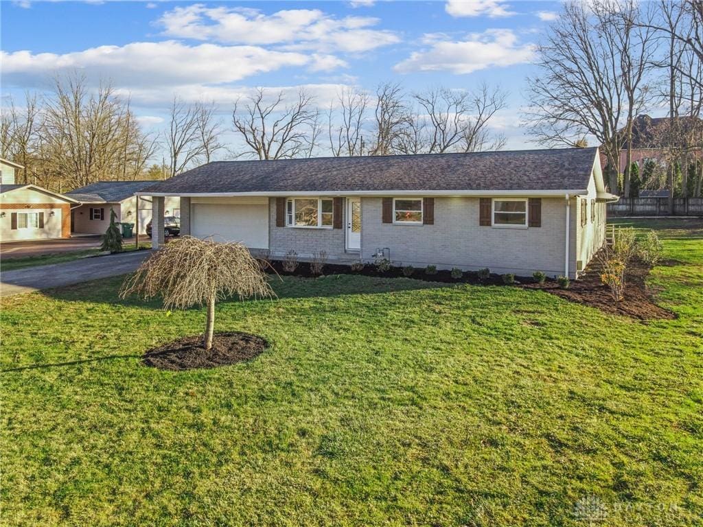 188 Windmere Dr, Troy, OH 45373 - ranch-style home featuring brick siding, an attached garage, a front yard, and aphalt driveway