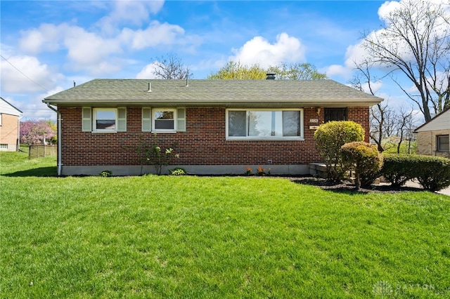 exterior space with a front lawn, brick siding, and a shingled roof