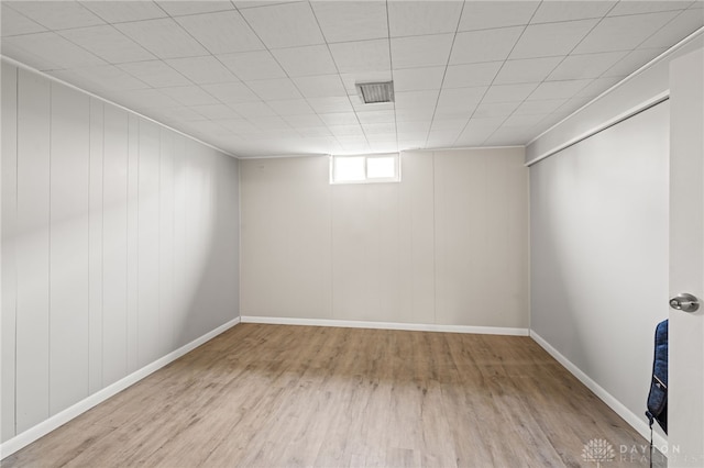 below grade area featuring baseboards, wood finished floors, and visible vents
