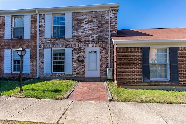view of front of house featuring brick siding and a front lawn