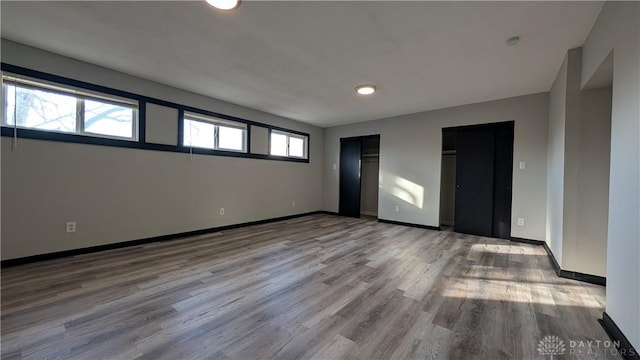 1105 Pursell Ave, Dayton, OH 45420 - unfurnished bedroom with wood finished floors, multiple closets, and recessed lighting